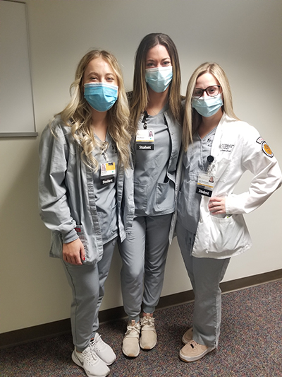 Photo of three radiologic tech student award recipients wearing gray scrubs and masks