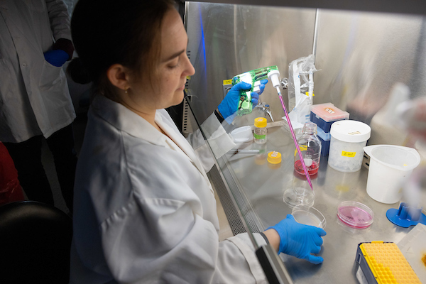 A woman in a lab conducts cancer research.