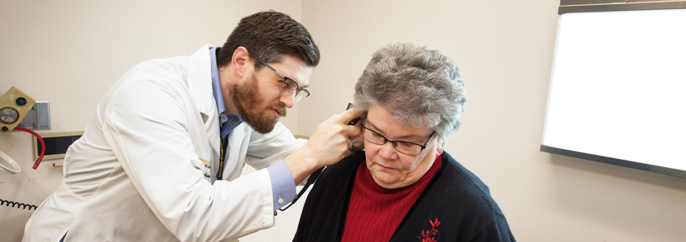 Family medicine provider checks a patient's ear