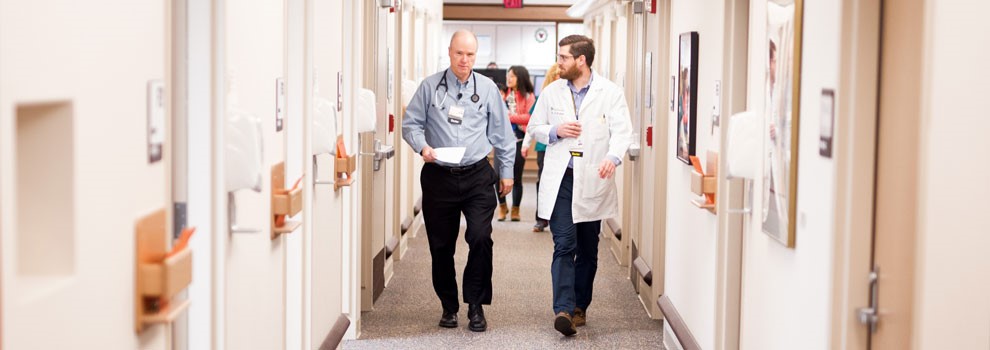 Two doctors walk down a hall together